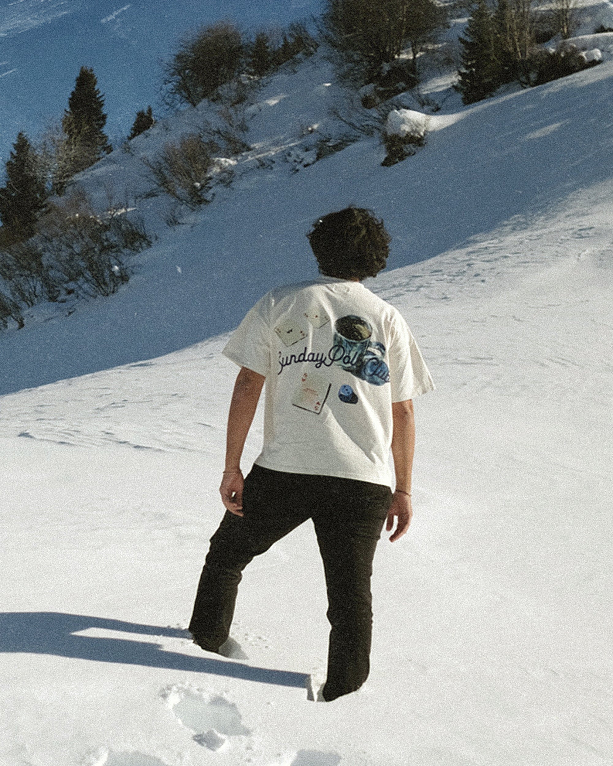 Person walking on a snow-covered slope with a scenic background