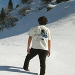 Person walking on a snow-covered slope with a scenic background
