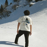 Person walking on a snow-covered slope with a scenic background